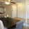 a dining table with chairs and a mirror in a room with white walls